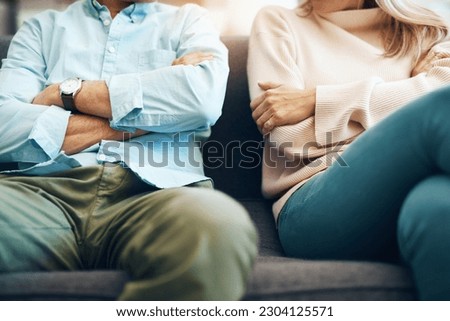 Divorce, angry and couple fight arms crossed due to family law problem in a marriage with conflict in a home lounge. Anger, living room and partner or people frustrated, depressed and mad on a sofa