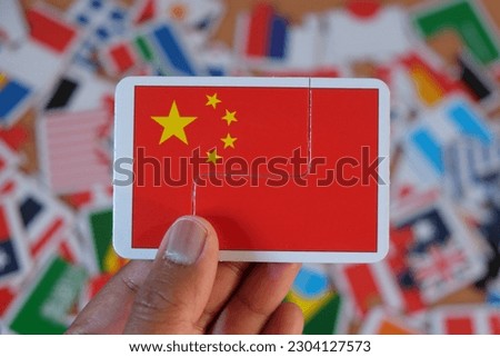 holding chinese flag puzzle over flags of world countries