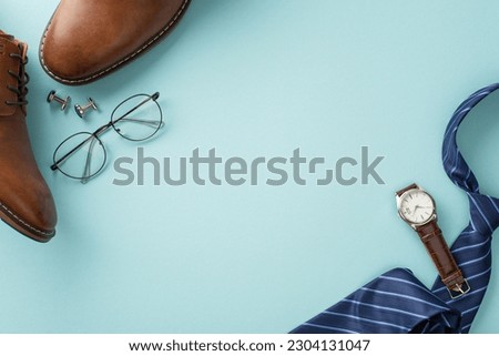 Classy Father's Day concept. Flat lay top view of silk necktie, leather shoes, wristwatch, spectacles, cufflinks, male accessories on pastel blue background with blank space for text or advertisement