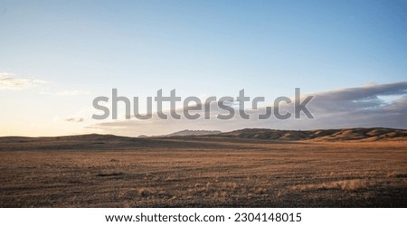 View of beautiful countryside at sunset. Beautiful autumn landscape in the hilly. Grassy field and hills. Rural landscapes. Royalty-Free Stock Photo #2304148015