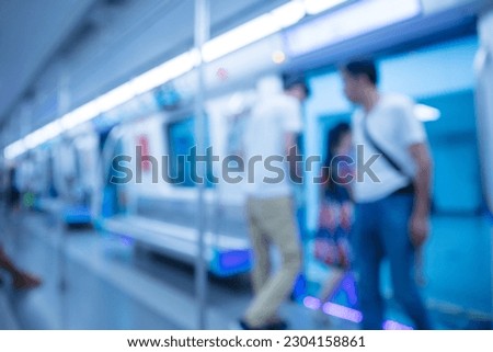 The subway arrives at the station, people getting on and off the train, defocused background effect