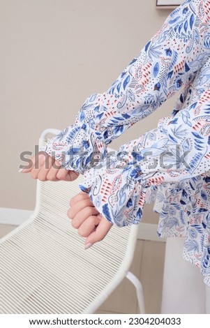 
photo of a woman's arm showing floral prints on clothes