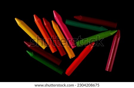 New wax pastel, colorful crayons group isolated on black, top view 