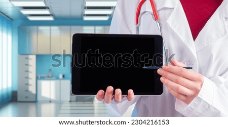 Doctor with tablet. Doctor in white coat. Clinic employee points to tablet. Concept therapist recommends. Recruited hospital worker. Doctor in clinic. Place for apps or website. Medicine, healthcare Royalty-Free Stock Photo #2304216153