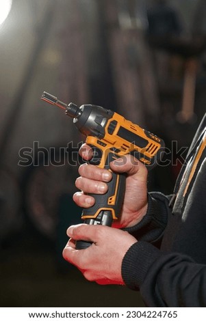 men's hands put in take out a replaceable battery from an electric wrench Royalty-Free Stock Photo #2304224765