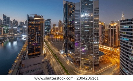 Cityscape of skyscrapers in Dubai Business Bay and downtown with water canal aerial night timelapse. Modern skyline with towers and waterfront after sunset. A center of international business