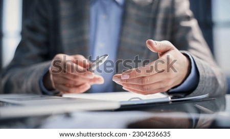 Holding pen in hand. Signing legal document. Businessman signing contract at table