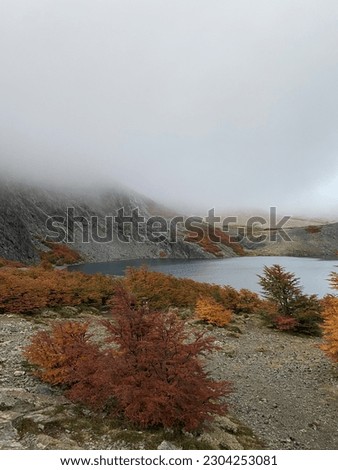 beautiful view of a lake in the mountains with lots of fall colors. Very cloudy day with a high probability of rain. the clouds were very low with respect to the ground.