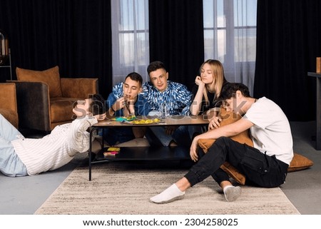 Five friends spending time together, get bored. Small group of friend in a living room, boring party or friends meeting.