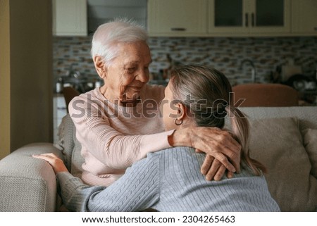 Grandmother and granddaughter hugging in the living room. Two adult women of different age. Family values concept. Close up, copy space, background. Royalty-Free Stock Photo #2304265463