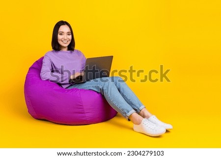 Full length size photo of positive lady sitting beanbag dorm room use netbook for remote part time job isolated on yellow color background Royalty-Free Stock Photo #2304279103