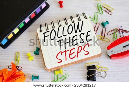 Follow these steps symbol. Concept words Follow these steps on white notebook. Beautiful wooden background. Business and Follow these steps concept. Copy space.