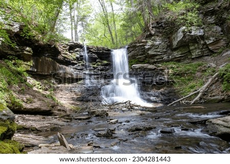 Time Stands Still: Long Exposure of a Waterfall Cascading Over Rocks Surrounded by Green Trees