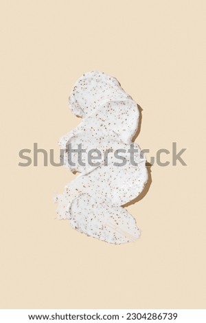 Smears of body scrub on beige background. Fruit and berry body scrub texture of the swatch. Cosmetic smear Royalty-Free Stock Photo #2304286739