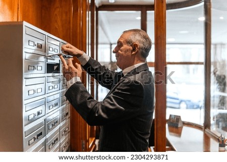 concierge opening the mailboxes of the residents of the building