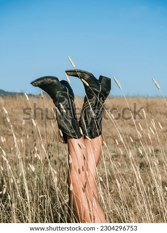 Cowboy Boots in the air in a Summer Field