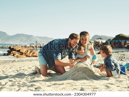 Sandcastle, parents and children at the beach with bonding, love and support. Baby, mom and dad together with kids playing in the sun with happiness and smile by the ocean and sea with family Royalty-Free Stock Photo #2304304977