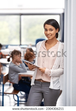 Teacher, tablet and portrait of a woman at school for education, teaching and career. Smile of a female person at the door of a classroom with children or students, tech and happiness at work
