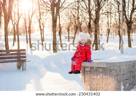 portrait of a little girl in winter having fun with snow