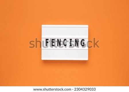 The word fencing on lightbox isolated orange background.
