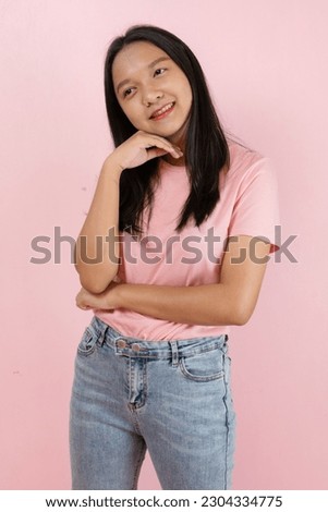Beautiful young girl smiling standing on pink background.