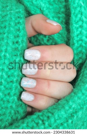 Stylish trendy female manicure.  Dairy nails on green  background. Nail polish. Art manicure. Modern style