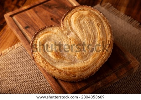 Oreja. Mexican sweet bread made with puff pastry, its name comes from its shape similar to that of ears, of French origin, where it is known as Elephant Ear or Palmier Puff Pastry. Royalty-Free Stock Photo #2304353609