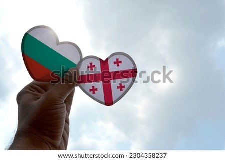Hand holds a heart Shape Bulgaria and Georgia flag, love between two countries