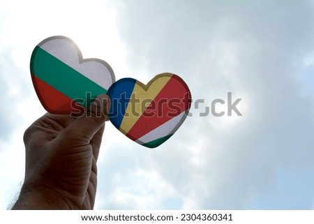 Hand holds a heart Shape Bulgaria and Seychelles flag, love between two countries