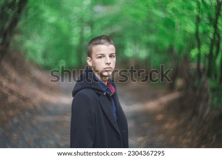 concept photo of a young man in a black coat and cap posing outdoors
