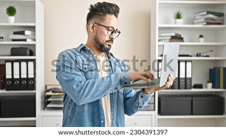 Young latin man business worker using laptop working at office