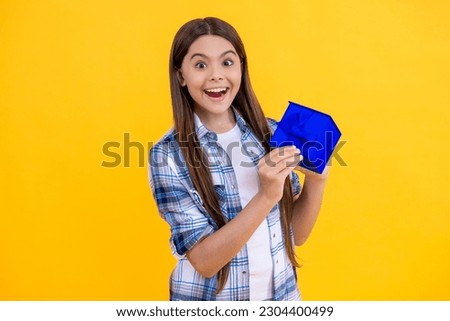 surprised birthday teen girl with birthday gift present box isolated on yellow