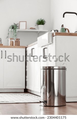 Metallic trash bin on floor in modern kitchen Royalty-Free Stock Photo #2304401175