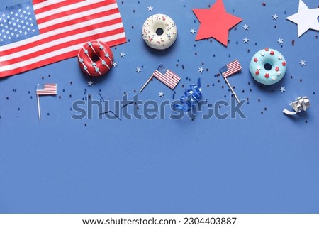 Composition with donuts, USA flags and confetti on blue background. Independence Day celebration