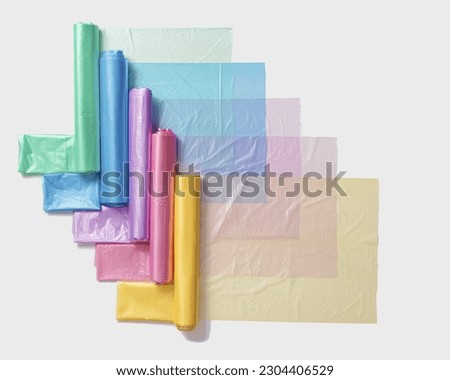 Colorful plastic bags in rolls as geometric pattern on white background. Eco plastic product bio bags for food, Plastic free environment protection concept, eco trend to reduce disposable plastic Royalty-Free Stock Photo #2304406529