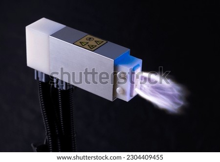 Plasma Technology for Surface Treatment. A advanced device is producing a purple cold plasma ray.  Royalty-Free Stock Photo #2304409455