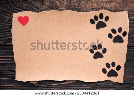 Postcard with paw foot trail icon and red heart, paper art style. Animal love concept, greeting card, invitation mockup. Flat lay, top view, copy space
