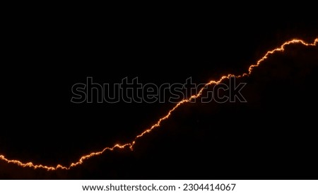 Night fire in the forest with fire and smoke.Epic aerial photo of a smoking wild flame.A blazing,glowing fire at night.Forest fires.Dry grass is burning. climate change,ecology.Line fire in the dark. Royalty-Free Stock Photo #2304414067