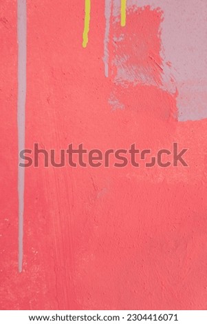 Messy paint strokes and smudges on an pink old painted wall. Colorful drips, flows, streaks of paint and paint sprays