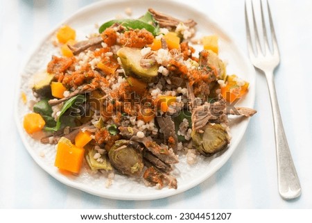 Pearl barley and beef salad with pickled pumpkin and brussel sprouts and red pepper dressing