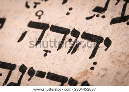 Hebrew word in Torah page. English translation is name Judah, the founder of the Israelite Tribe of Judah. Fourth of the six sons of Jacob and Leah. Selective focus. Closeup Royalty-Free Stock Photo #2304452837