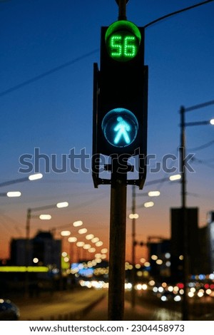 Car traffic light for pedestrians, traffic lights, road signals for safe across the road, in the evening in the city 