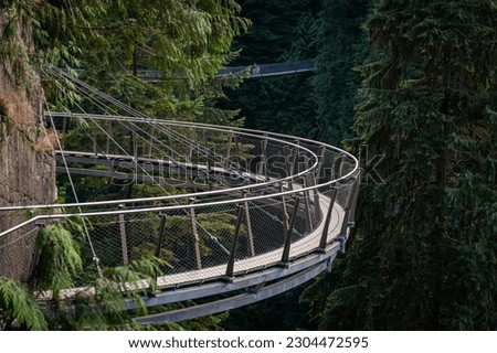 Cliffwalk's narrow walkways and grainy floors generate adrenaline-pumping trips into the forest. Not for the faint of heart, the Cliffwalk juts out from the granite cliff face above the Capilano River Royalty-Free Stock Photo #2304472595