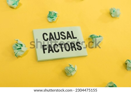 On a light background, black pencils, black paper clips, a pen and a sheet of white paper with the text CAUSAL FACTOR Royalty-Free Stock Photo #2304475155