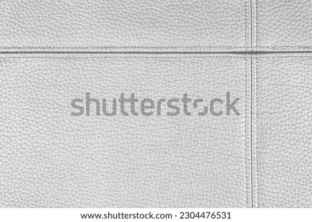 Natural, artificial silver gray leather texture background with decorative seam. Material for sport items, clothes, furnitre and interior design. ecological friendly leatherette. Royalty-Free Stock Photo #2304476531