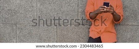 Happy african young man listening music with headphones outdoors while wearing safety mask - Focus on face