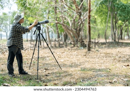 Bird watchers with tripod and spotting scope. Royalty-Free Stock Photo #2304494763