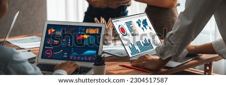 Panorama shot analyst team utilizing BI Fintech to analyze financial report with laptop. Businesspeople analyzing BI power dashboard displayed on laptop screen for business insight. Scrutinize Royalty-Free Stock Photo #2304517587