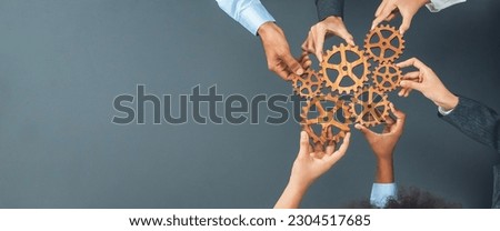 Panoramic shot top view of business people holding cog wheel as unity and teamwork in corporate workplace concept. Office worker colleague with symbol of visionary system for business success. Concord Royalty-Free Stock Photo #2304517685