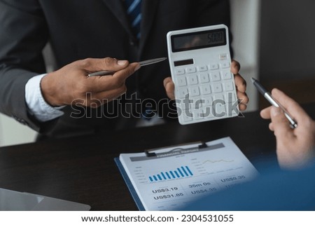 Team of business people working on desk using calculator calculate numbers from data sheet on business chart graph. financial concept.